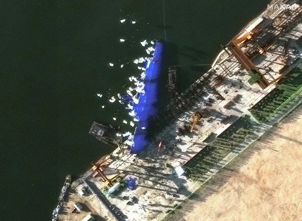 Maxar satellite imagery reveals the latest view of the crippled destroyer at Hambuk Shipyard. The ship remains unmoved and heavily obscured with blue tarps, as personnel and cranes gather nearby, suggesting ongoing salvage or damage assessment efforts. Please use: Satellite image (c) 2025 Maxar Technologies.