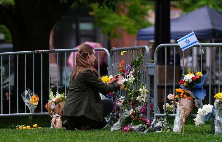 A woman places a bouquet of flowers at a makeshift memorial for victims of an attack outside of the Boulder County, Colorado, courthouse Tuesday, June 3, 2025, in Boulder.