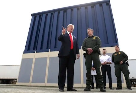 FILE - In this March 13, 2018, file photo, President Donald Trump speaks during as he reviews border wall prototypes, in San Diego, as Rodney Scott, the Border Patrol's San Diego sector chief, listens. Congress is heading toward a post-election showdown over President Donald Trump’s border wall, as GOP leaders signal they’re willing to engage in hardball tactics that could spark a partial government shutdown and the president revs up midterm crowds for the wall, a centerpiece of his 2016 campaign and a top White House priority. (AP Photo/Evan Vucci, File)