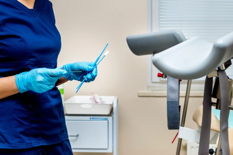 Gynecologist holds instruments for taking tests from a woman. Gynecologist's office