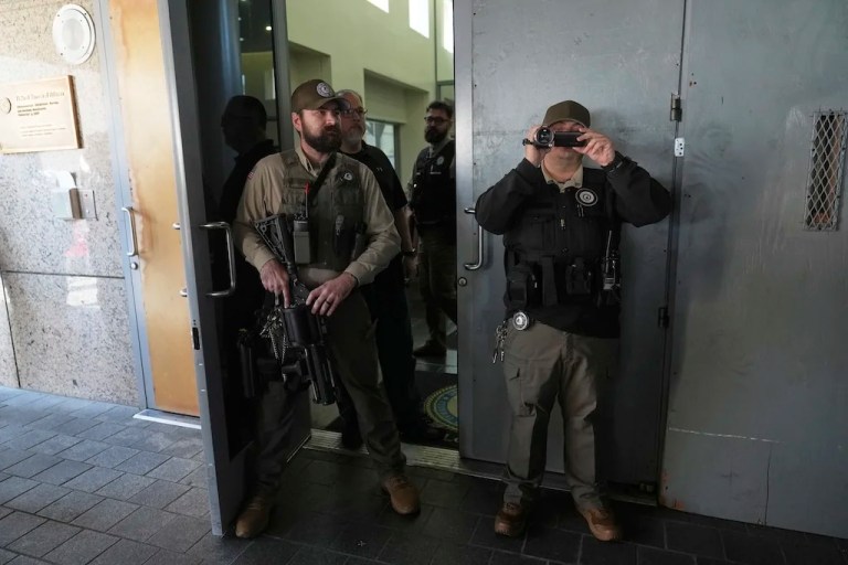 Law enforcement watch protesters at the U.S. Department of Justice Federal Bureau of Prisons after federal immigration authorities conducted an operation on Friday, June 6, 2025, in Los Angeles. (AP Photo/Jae C. Hong)