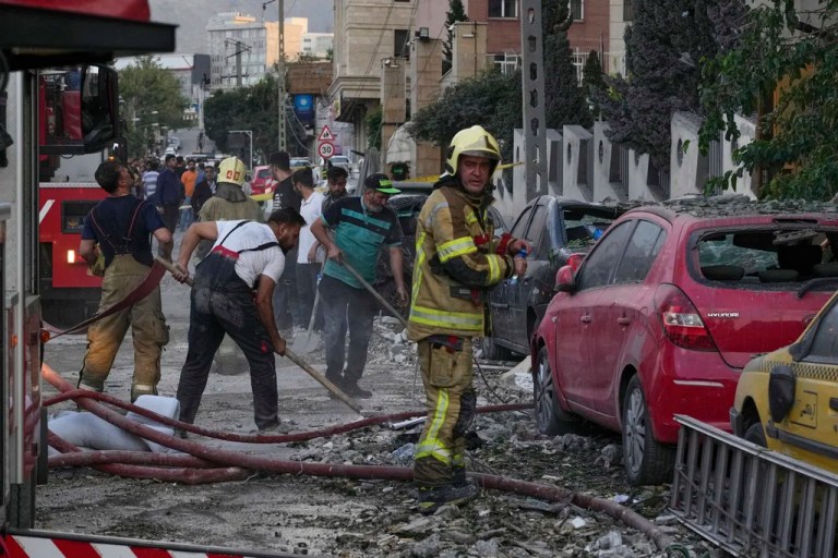 Firefighters and people clean up the scene of an explosion at a residence compound after Israeli attacks in Tehran, Friday, June 13, 2025. (AP Photo/Vahid Salemi)