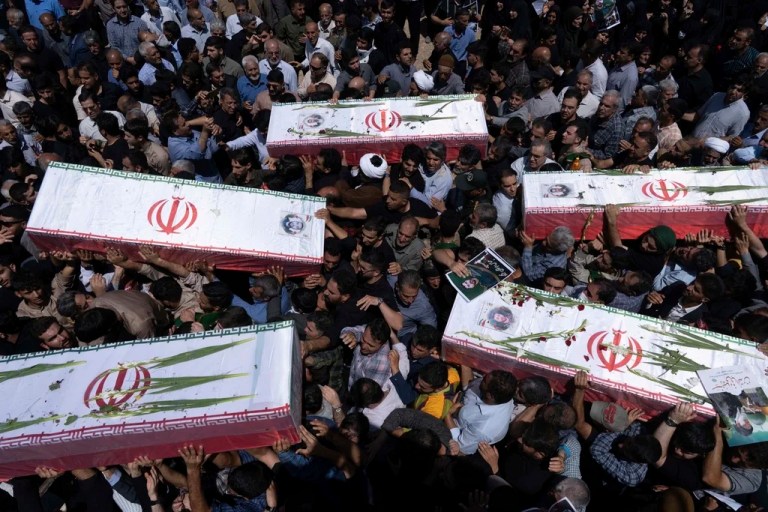 Mourners carry the flag-draped coffins of five men, whose names were not immediately available, reportedly killed in Israeli strikes, during their funeral in the city of Khorramabad, Iran, Monday, June 16, 2025.