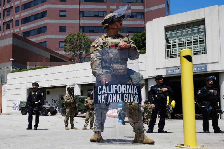 U.S. National Guard stand protect buildings Tuesday, June 10, 2025, in Los Angeles. (AP Photo Damian Dovarganes)