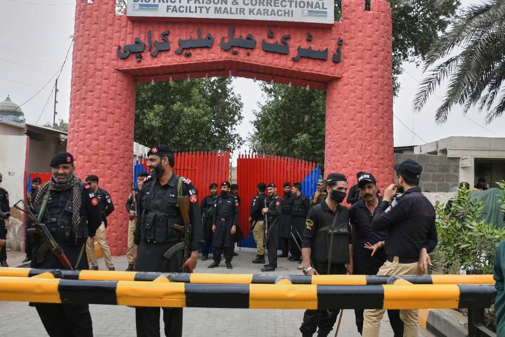Police officer and paramilitary soldiers stand guard outside the district Malir prison, from where more than 100 inmates escaped overnight, in Karachi, Pakistan, Tuesday, June 3, 2025. 