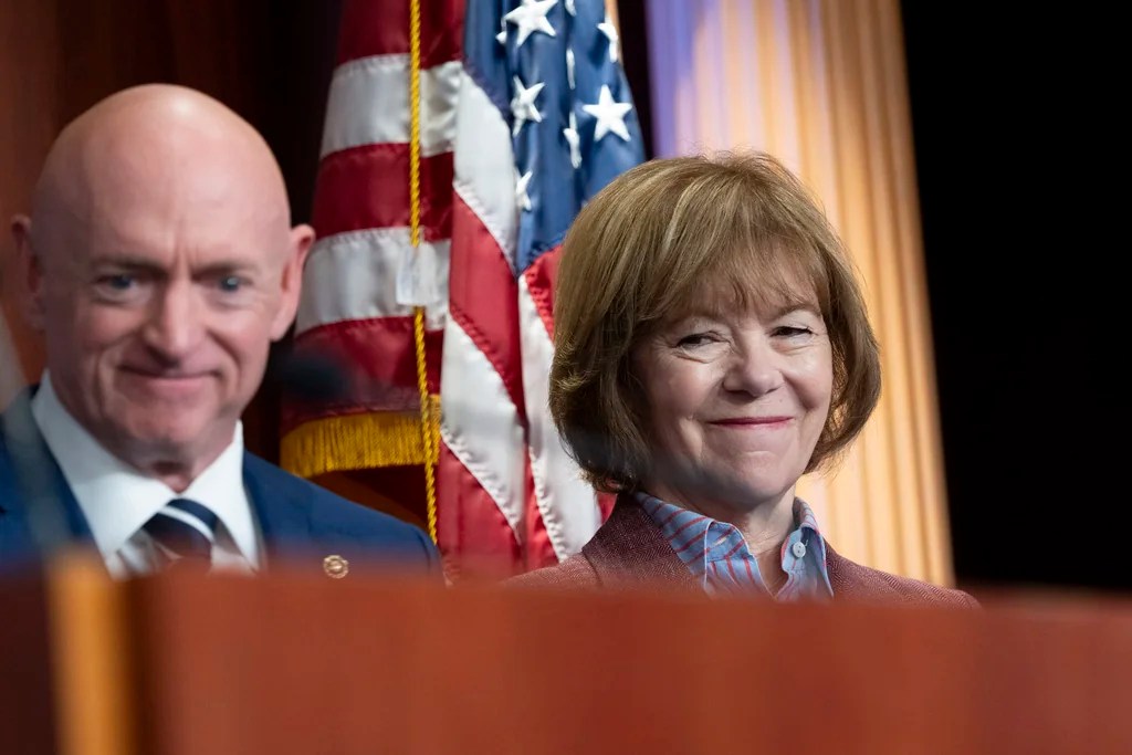 Sen. Tina Smith, D-Minn., smiles as she stands by Sen. Mark Kelly, D-Ariz., left, at a news conference on the Project 2025 agenda, Thursday, Sept. 12, 2024, at the Capitol in Washington.