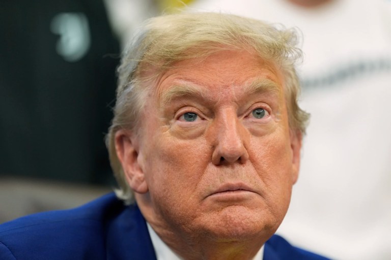 President Donald Trump talks with reporters in the Oval Office.