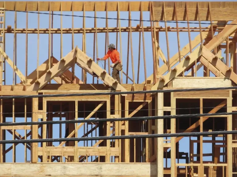 A construction worker examines part of a building under construction.
