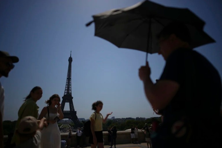 People walk at Trocadéro plaza near the Eiffel Tower during a heat wave, Wednesday, July 2, 2025 in Paris.