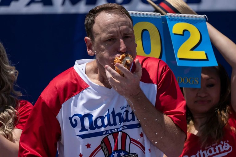 Competitive eater Joey Chestnut eats hot dogs during the 2025 Nathan's Famous Fourth of July hot dog eating contest in the Coney Island section of the Brooklyn borough of New York, Thursday, July 4, 2025.