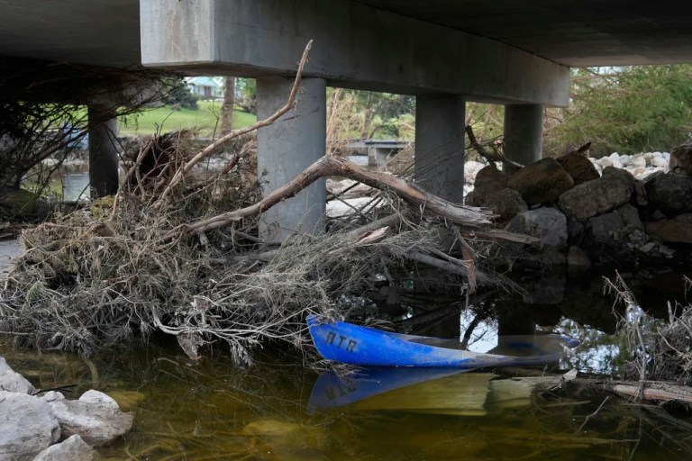 A small boat and tree limbs are left behind after flooding in Kerrville, Texas on Wednesday, July 9, 2025. (AP Photo/Ashley Landis)