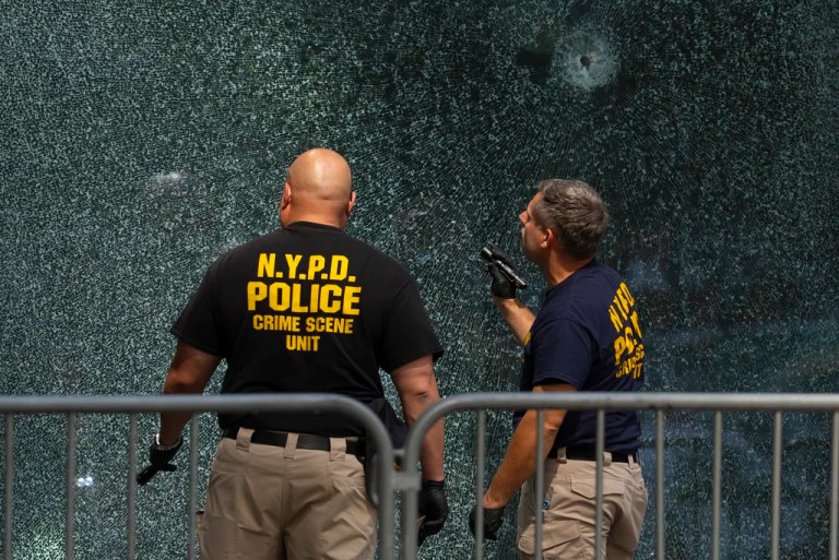 Members of NYPD Crime Unit examine a door with bullet holes at the scene of Monday's deadly shooting, Tuesday, July 29, 2025, in New York.