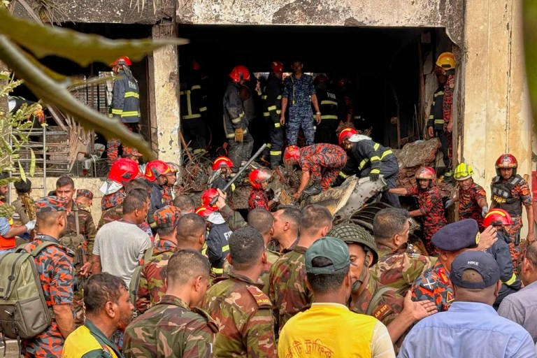 Firemen check the wreckage of a Bangladesh Air Force training aircraft that crashed onto a school campus in Dhaka, Bangladesh, Monday, July 21, 2025.