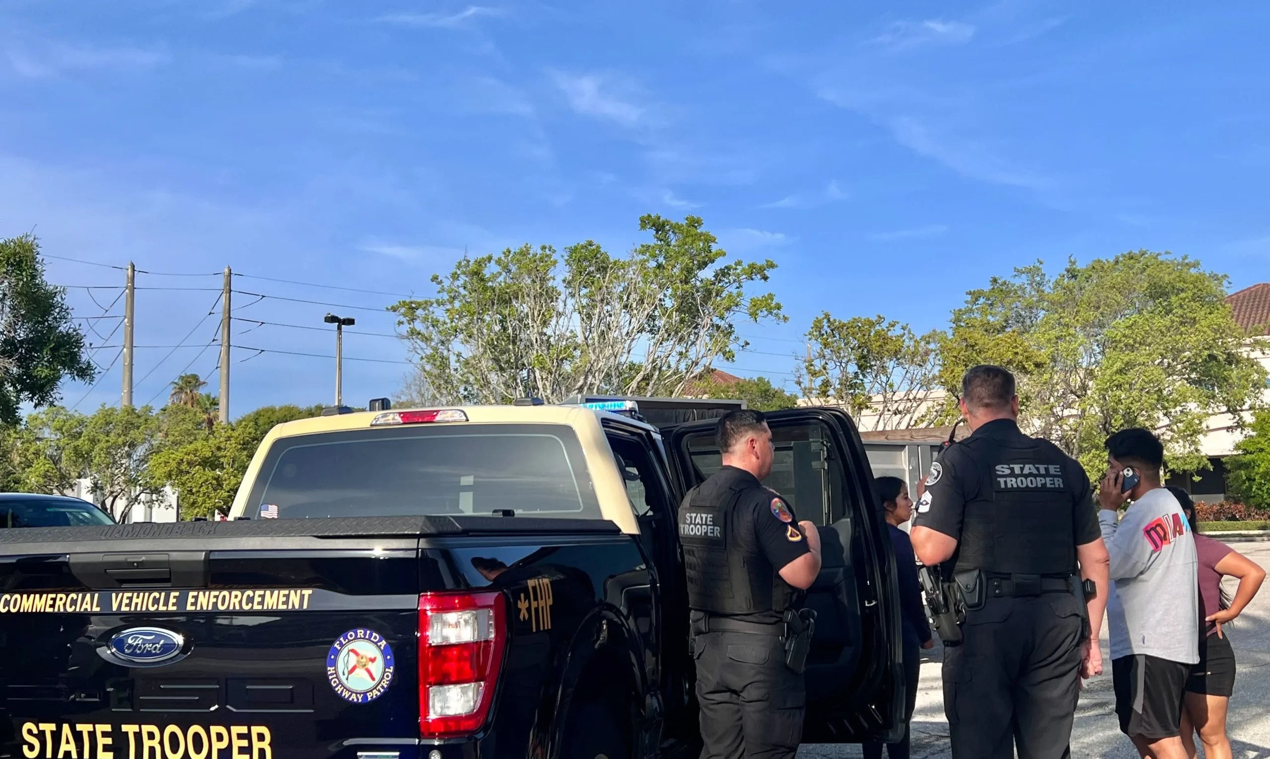 The family of a man detained by Florida Highway Patrol stands around a detained man who was driving a dump truck.(Anna Giaritelli / Washington Examiner)