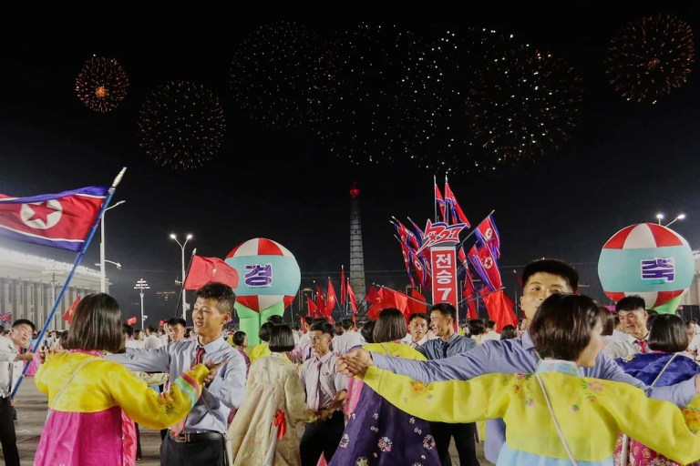 North Korean youth and students dance during an evening gala with a firework display to celebrate the 72nd anniversary of the armistice of the Korean War, at Kim Il Sung Square in Pyongyang, North Korea, Saturday, July 26, 2025.