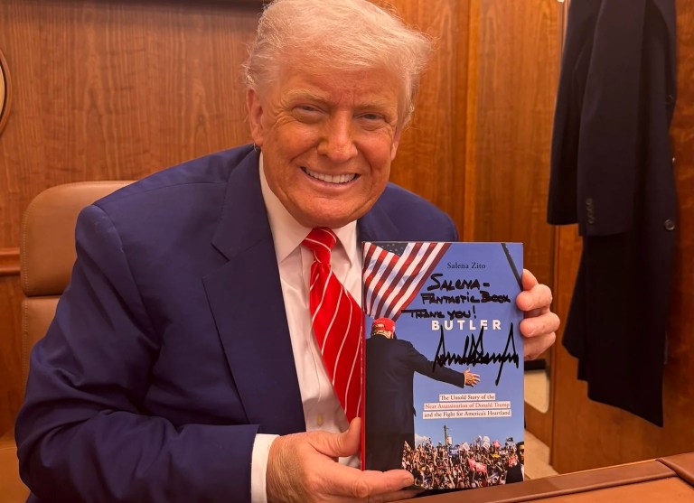 President Donald Trump displays the newest book by the 