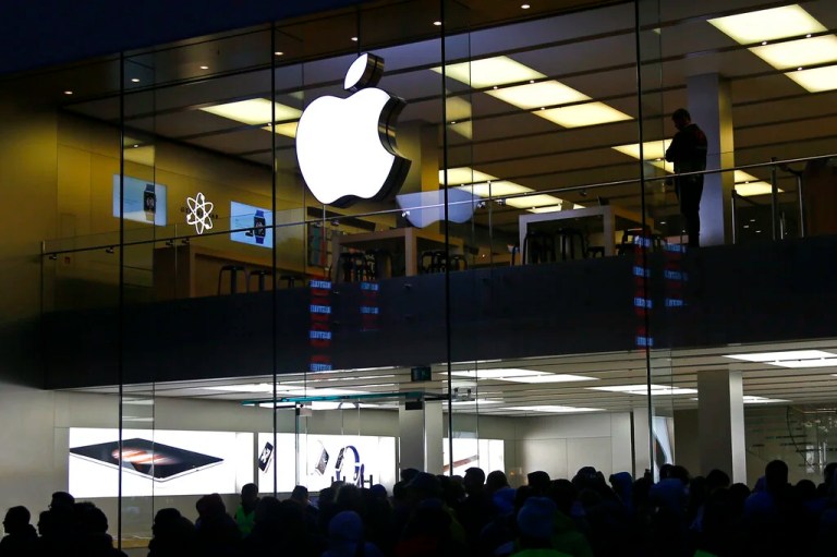 In this Sept. 25, 2015 file photo, people wait in front of the Apple store in Munich, Germany. Apple’s Identifier for Advertisers allows Apple and all apps on the phone to track a user and combine information about online and mobile behavior. Just like for cookies, this would require the users’ consent under EU law. Apple places these tracking codes without the knowledge or agreement of the users. noyb therefore filed two complaints against the company.