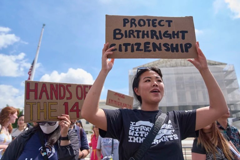 FILE - Hannah Liu, 26, of Washington, holds up a sign in support of birthright citizenship, May 15, 2025, outside of the Supreme Court in Washington. 