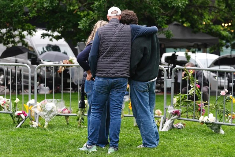 As Jennifer Dechtman, back, looks on, her husband Evan, front left, consoles his son, Isaac, right, at a makeshift memorial for victims of an attack outside of the Boulder County, Colorado, courthouse Tuesday, June 3, 2025.
