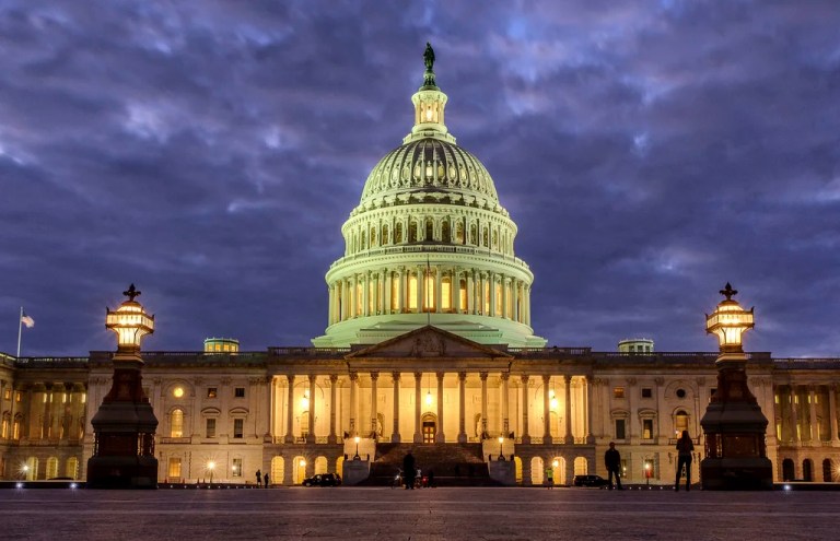 Lights shine inside the U.S. Capitol Building as night falls on Jan. 21, 2018, in Washington.