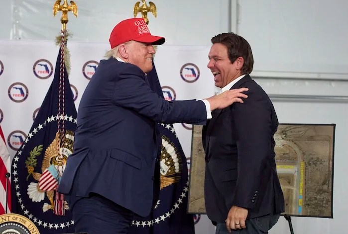 President Donald Trump talks with Gov. Ron DeSantis, R-Fla., during a roundtable at 