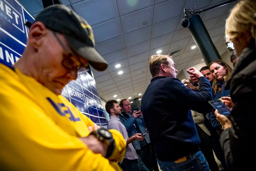 Democratic presidential candidate Sen. Michael Bennet, D-Colo., center, accompanied by James Carville, a political commentator known for leading former President Bill Clinton's 1992 presidential campaign, left, speaks to members of the media before a campaign stop at the Spotlight Room at the Palace, Saturday, Feb. 8, 2020, in Manchester, N.H.