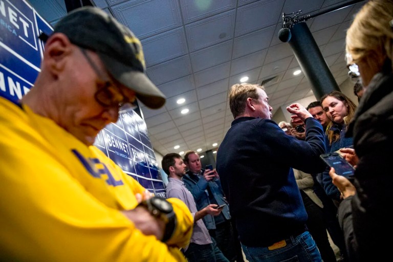 Democratic presidential candidate Sen. Michael Bennet, D-Colo., center, accompanied by James Carville, a political commentator known for leading former President Bill Clinton's 1992 presidential campaign, left, speaks to members of the media before a campaign stop at the Spotlight Room at the Palace, Saturday, Feb. 8, 2020, in Manchester, N.H.
