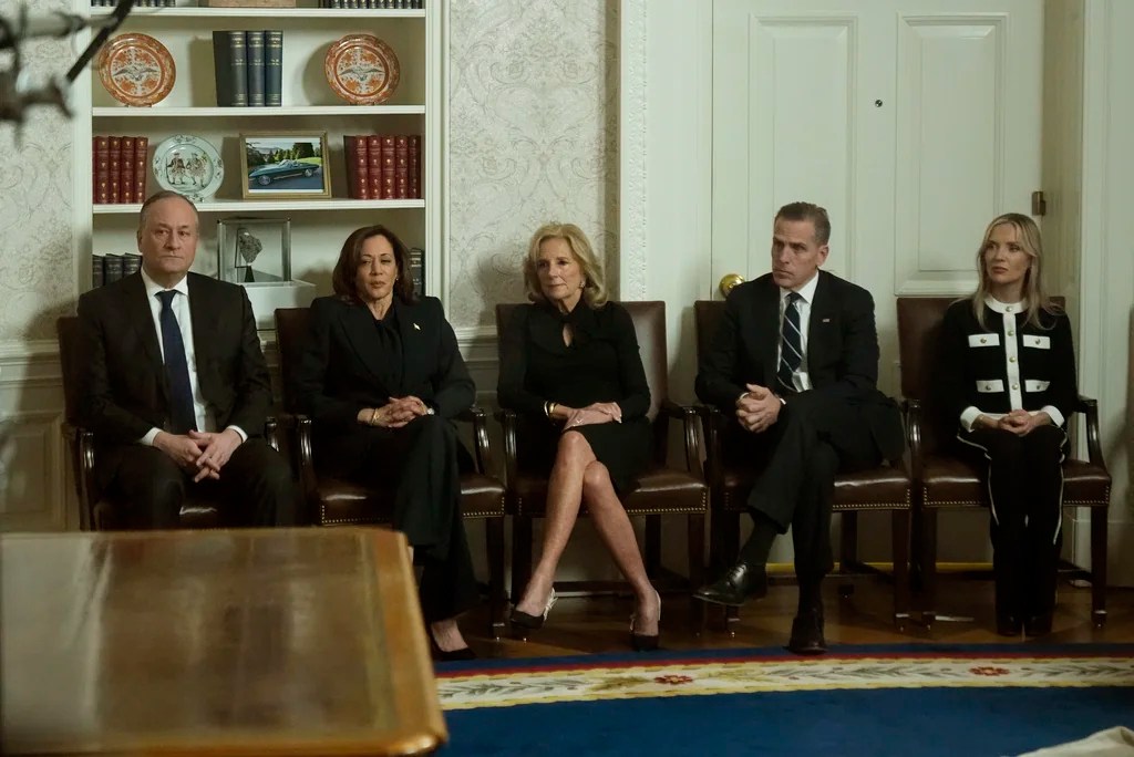 As seen through a window from the Colonnade outside the Oval Office, second gentleman Doug Emhoff, Vice President Kamala Harris, first lady Jill Biden, Hunter Biden and Melissa Cohen Biden watch as President Joe Biden speaks during his farewell address at the White House in Washington, Wednesday, Jan. 15, 2025.
