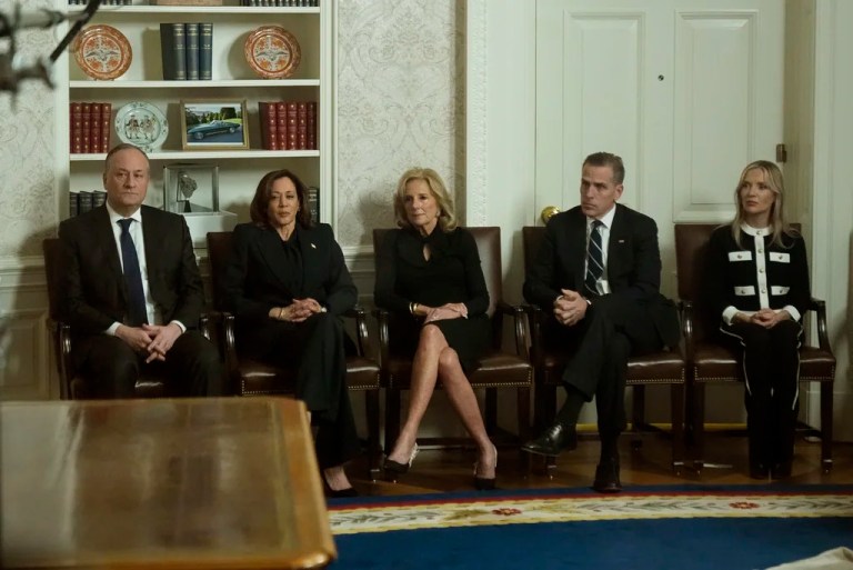 As seen through a window from the Colonnade outside the Oval Office, second gentleman Doug Emhoff, Vice President Kamala Harris, first lady Jill Biden, Hunter Biden and Melissa Cohen Biden watch as President Joe Biden speaks during his farewell address at the White House in Washington, Wednesday, Jan. 15, 2025.
