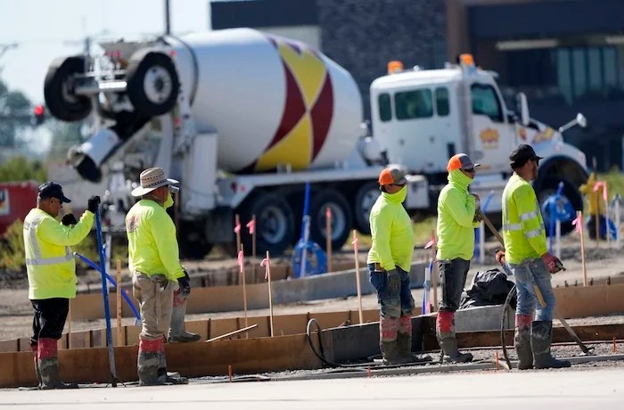 Jobs report - Construction crew members wait to pour concrete in a parking lot on Sept. 4, 2024, in Waukee, Iowa