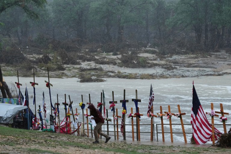 Rain falls over a makeshift memorial for flood victims along the Guadalupe River, Sunday, July 13, 2025, in Kerrville, Texas. (AP Photo/Eric Gay)