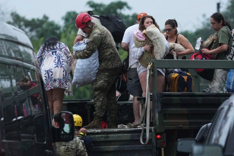 First responders deliver people to a reunification center after flash flooding in the area, Friday, July 4, 2025, in Ingram, Texas.