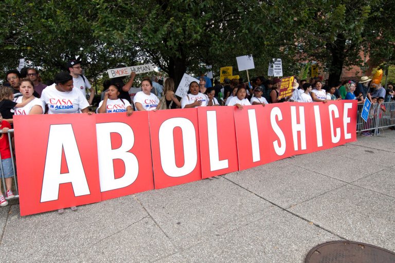 Protestors hold a sings spelling abolish ice