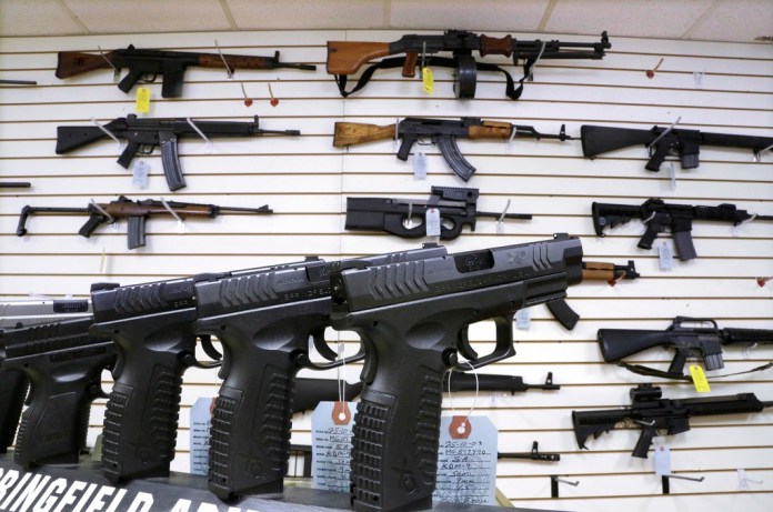 FILE - Assault weapons and handguns are seen for sale at Capitol City Arms Supply on Jan. 16, 2013, in Springfield, Ill. The Illinois Supreme Court will issue an opinion on the state's ban on the sale or possession of semi-automatic weapons of the type used in the 2022 Independence Day shooting in the Chicago suburb of Highland Park that killed seven and dozens of other mass shootings nationally. Rep. Dan Caulkins, a Decatur Republican, and other gun owners of Macon County filed the lawsuit contending the law not only violates the Second Amendment but equal protection of the laws because it exempts police and military from the ban. (AP Photo/Seth Perlman, File)