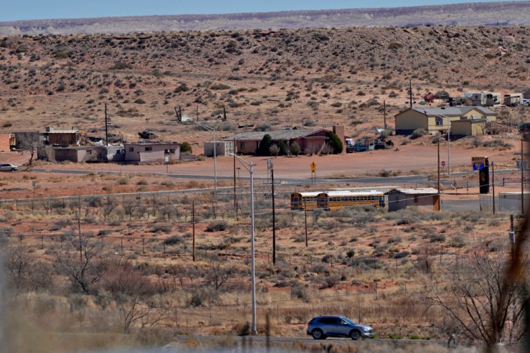 A motorist travels on the Navajo Nation along U.S. 160, Monday, March 4, 2024, in Tuba City, Ariz. with the Hopi reservation shown in the background. This stretch of highway is the de facto border between the Navajo and Hopi Indian reservations and two time zones. Mind-bending time calculations is what people in the largest Native American reservation in the U.S. have to endure every March through November.