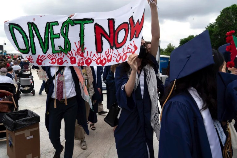 George Washington University students walk with a banner reading 