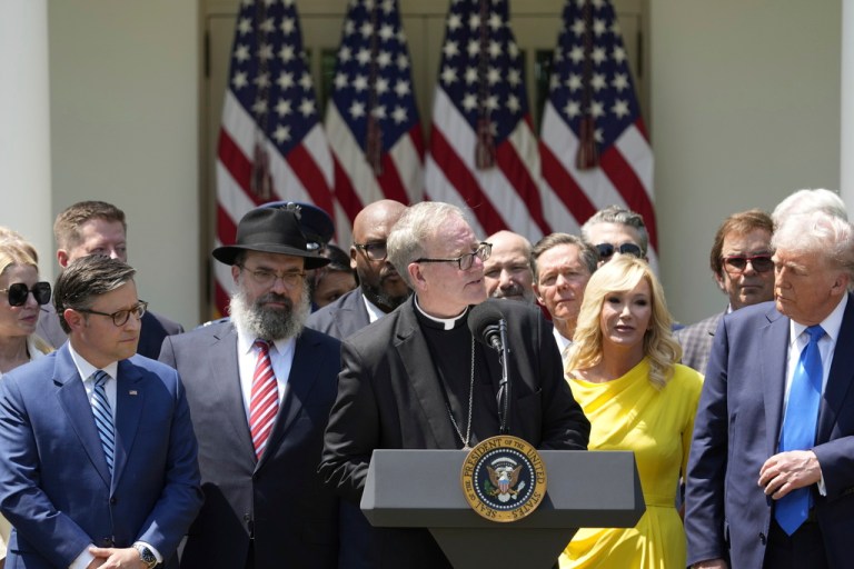 Bishop Robert Barron, with from left front, House Speaker Mike Johnson (R-LA), Rabbi Levi Shemtov, Pastor Paula White, and President Donald Trump, speaks during a National Day of Prayer event in the Rose Garden of the White House, Thursday, May 1, 2025, in Washington.