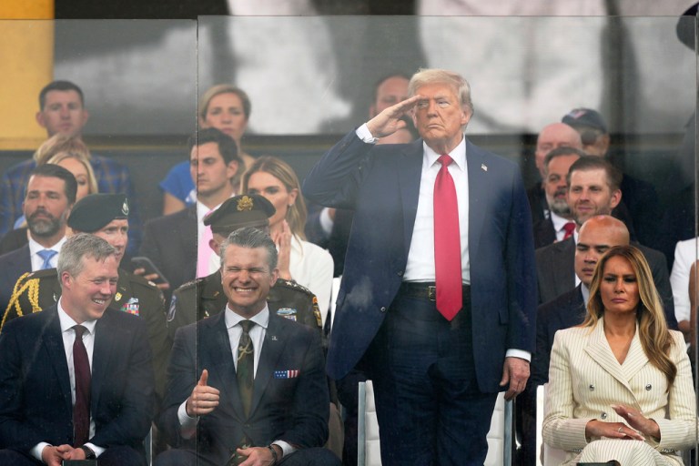 President Donald Trump salutes as he attends a military parade commemorating the Army's 250th anniversary