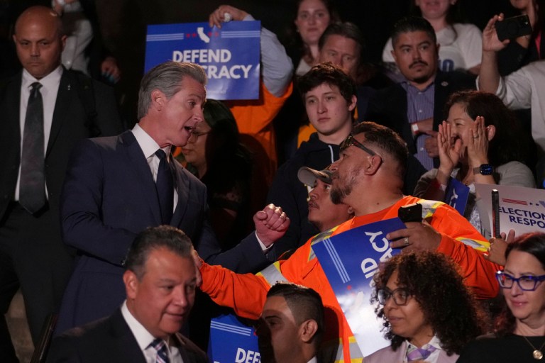 California Gov. Gavin Newsom, left, greets people as he arrives for a news conference Thursday, Aug. 14, 2025, in Los Angeles.