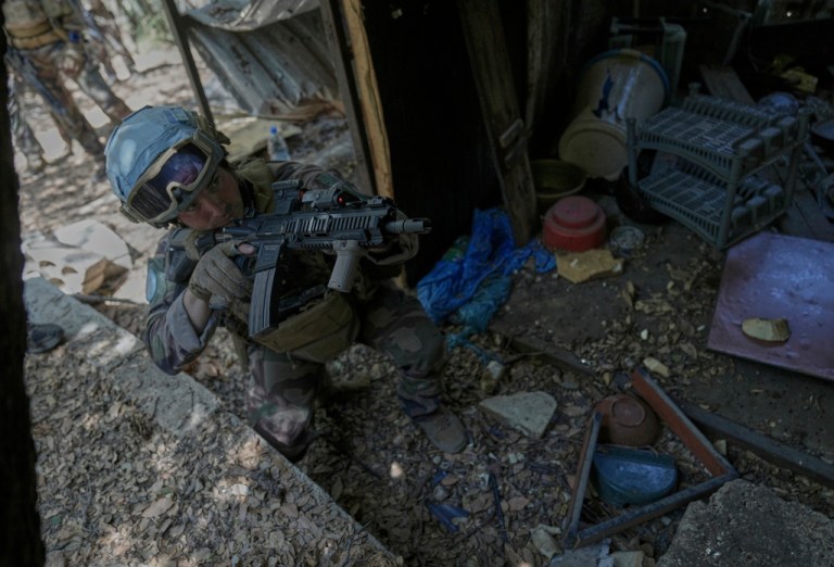 A French United Nations peacekeeper takes position as he enters a damaged room once used by Hezbollah fighters.
