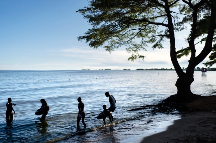 People wade into the waters of Lake Victoria, the world's second-largest freshwater lake, Nov. 25, 2024, in Entebbe, Uganda. (AP Photo/David Goldman, File)