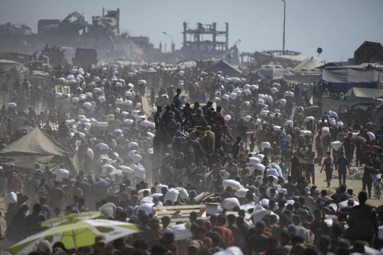 Palestinians carry sacks of flour taken from a humanitarian aid convoy.