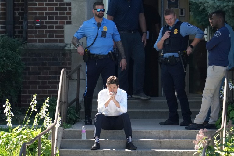 Minneapolis Mayor Jacob Frey sits on the steps of the Annunciation Church's school as police respond to a reported mass shooting.