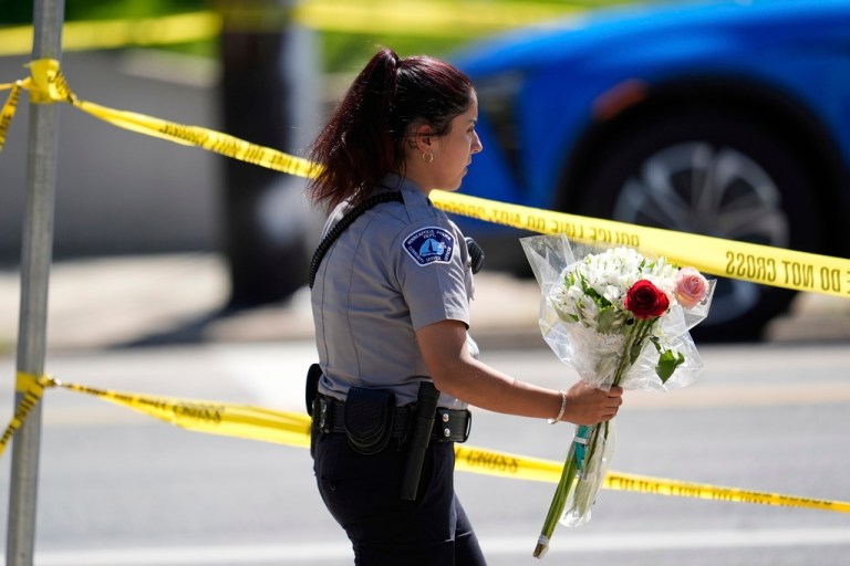 A police officer carries flowers outside the Minneapolis Catholic church and school in honor of the victims.