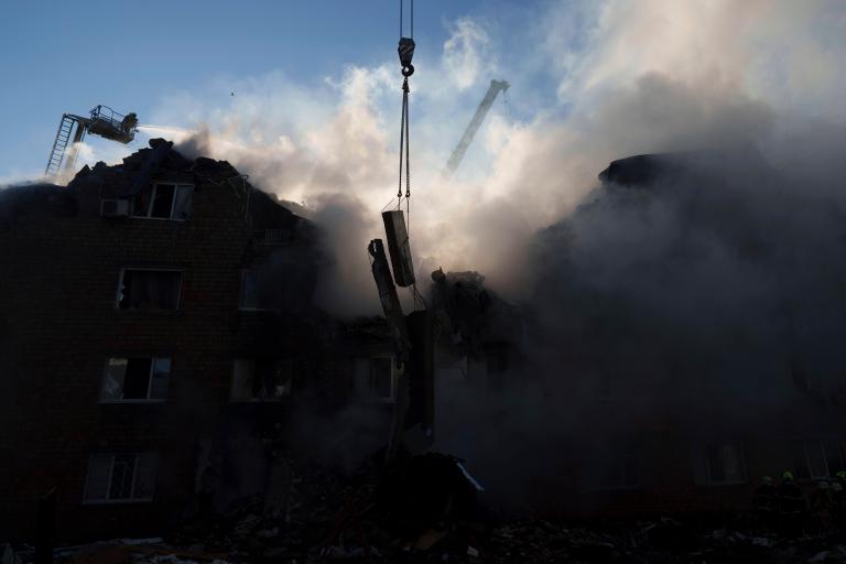 A rescue worker puts out a fire of a residential house destroyed by a Russian strike in Kyiv, Ukraine, on Thursday, Aug. 28, 2025.