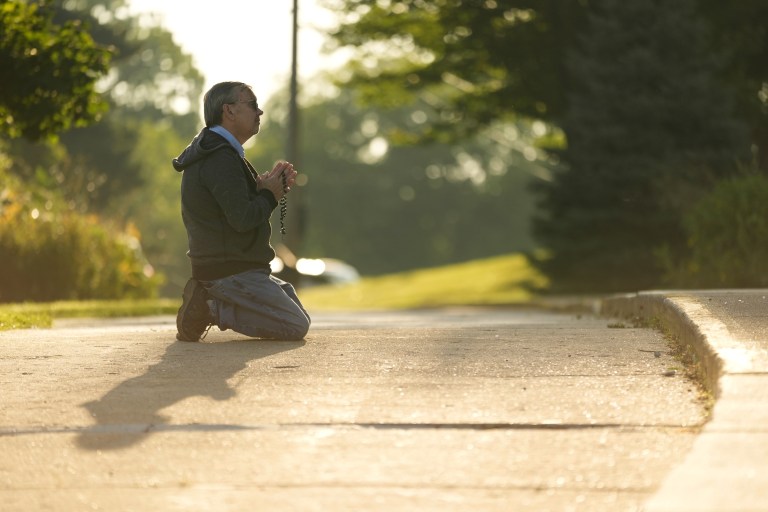 Tim Barr prays on a street near the Annunciation Catholic Church.