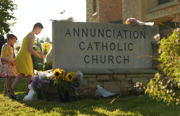 Minneapolis residents place flowers at a memorial outside Annunciation Church after Wednesday's shooting.