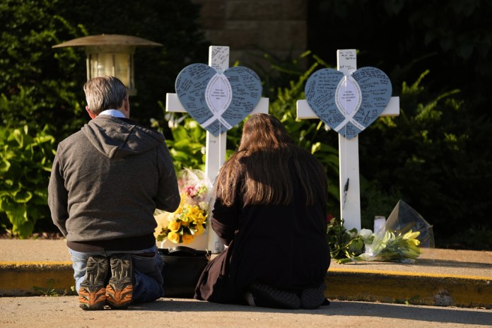 Tim and Katharine Barr kneel and pray at a memorial at Annunciation Catholic Church after Wednesday's school shooting, Thursday, Aug. 28, 2025, in Minneapolis.