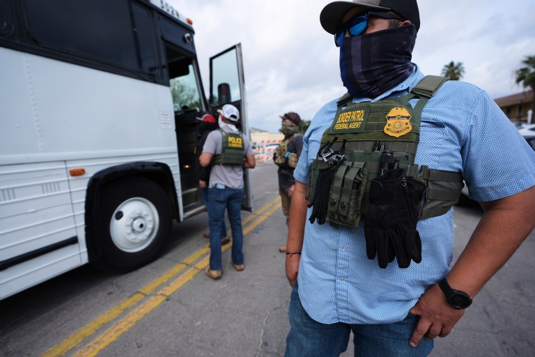 A Border Patrol agent looks on as a family from Colombia is detained and escorted to a bus by federal agents following an appearance at immigration court Monday, July 14, 2025, in San Antonio.