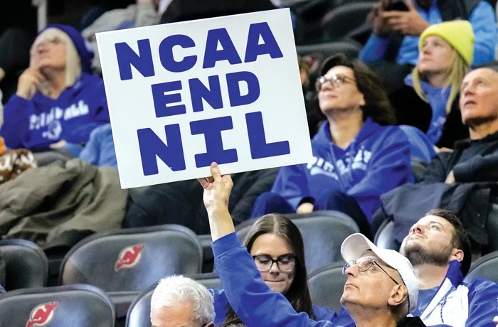 A fan holds a sign about name, image, and likeness during a college basketball game between Seton Hall University and DePaul University in Newark, New Jersey, Jan. 8, 2025. (Porter Binks/Getty Images)
